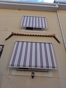 Toldos cofre de punto recto con lona de rayas desplegados en una vivienda de Arganda del Rey.